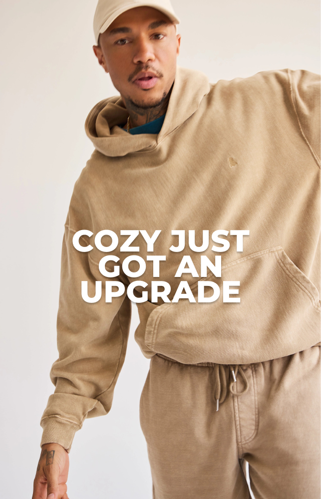 Man in tan hoodie with text "COZY JUST GOT AN UPGRADE"